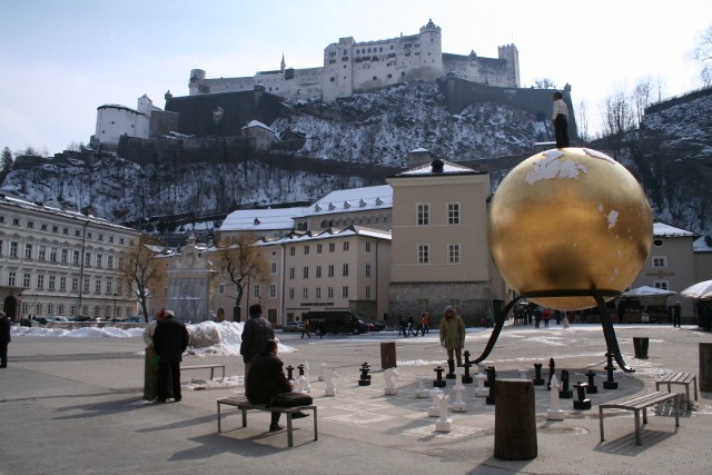 Moderne Kunst in Salzburg. Schachbrett neben goldener Kugel mit Mann